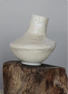 Jarrón de cerámica artesanal sobre tronco de madera