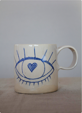 Taza de cerámica artesanal pintada a mano con motivo de ojo y corazón