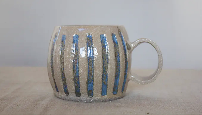 Taza de cerámica artesanal abombada con rayas azules