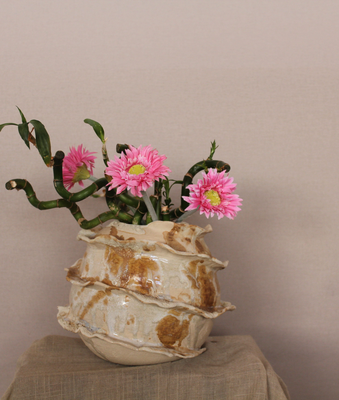 Jarrón de cerámica artesanal en tonos crema con flores rosas