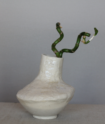 Jarrón de cerámica artesanal blanco de cuello estrecho con una rama verde