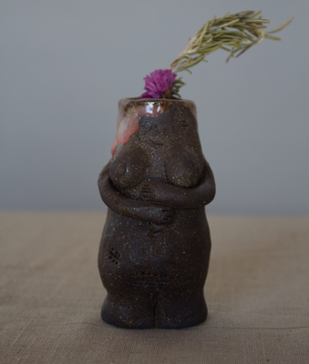 Meraki de cerámica artesanal con una flor rosa y una espiga seca