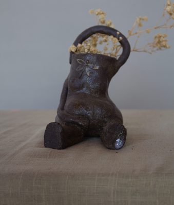 Meraki de cerámica artesanal sentada con un ramo de flores secas