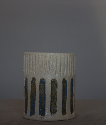 Taza de cerámica artesanal sin asa con rayas verticales azules y marrones